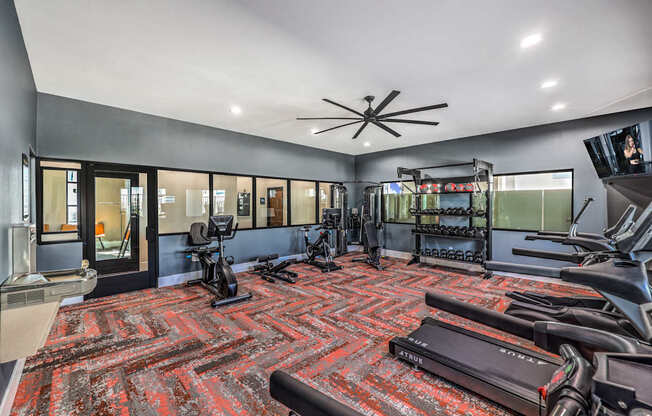 Modern fitness center at Summit on Boulder Apartments with state-of-the-art gym equipment, vibrant flooring, and spacious layout for an energizing workout experience.
