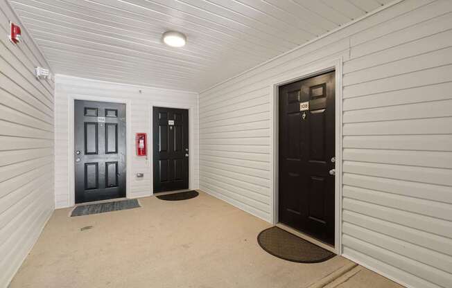 A hallway with two doors, one of which is open.
