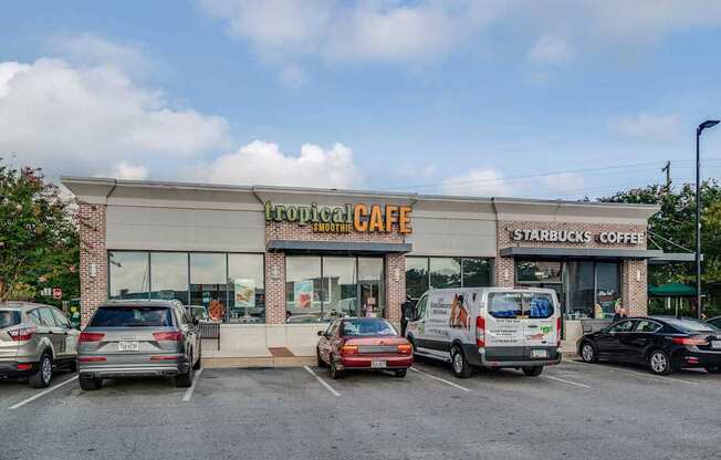 A Starbucks Coffee shop with a parking lot in front.