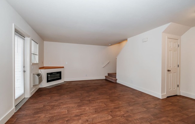 a living room with white walls and a wooden floor