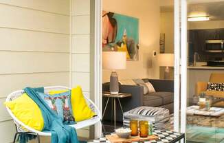A white chair with a blue blanket is on a blue rug.