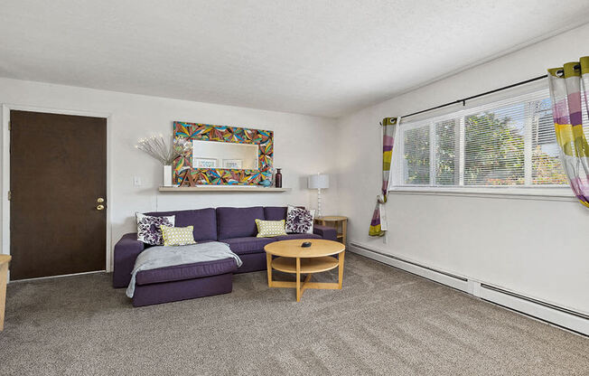 a living room with a purple couch and a table