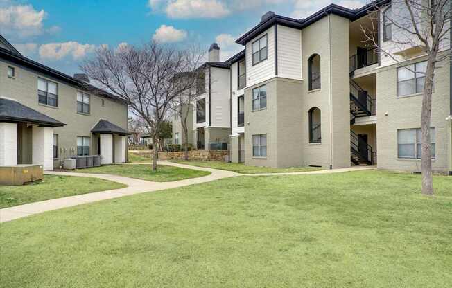 Apartment complex with a green lawn in front.