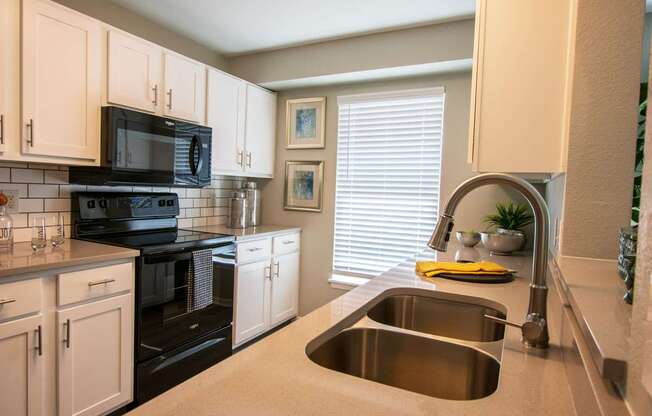 A kitchen with a black stove top oven and a black microwave.