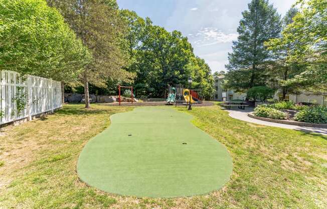 a mini golf course in a backyard with trees and a fence