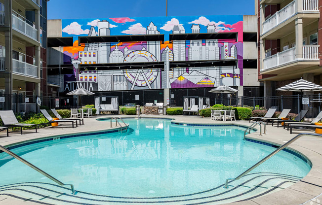 a swimming pool in front of a building with a mural on it