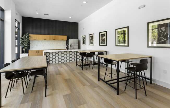 a dining room with tables and chairs and a kitchen