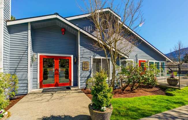 the front of a blue house with a red door