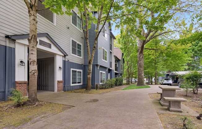 A tree-lined walkway leads to a building with a sign that reads "RESIDENTS".