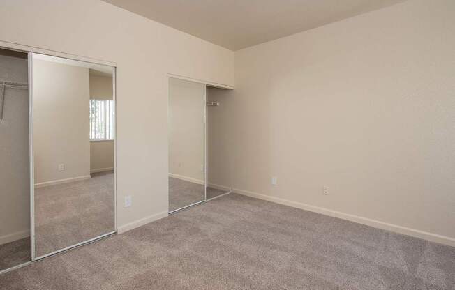 A room with a carpeted floor and mirrored closet doors at Sunset Summit, Rocklin, CA, 95765