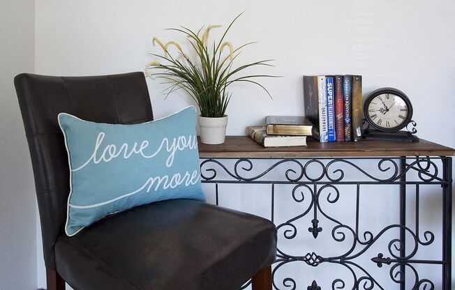 Sage Creek Apartments chair with accent pillow and table with books