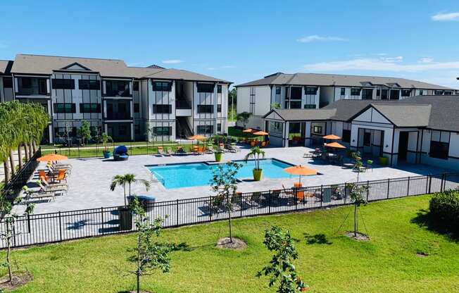 an aerial view of a swimming pool with apartments in the background