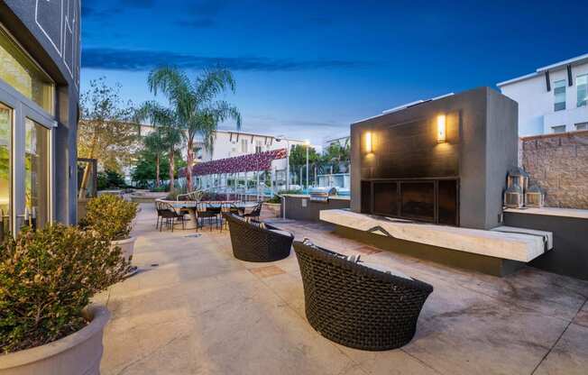 a patio with wicker furniture and a building at night