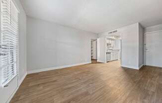 a bedroom with a hardwood floor and white walls