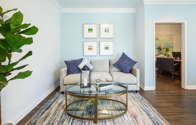 a living room with blue walls and a glass coffee table