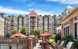 A large building with a pool in front of it at Vermella Lyndhurst apartments, New Jersey