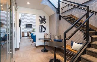 a living room with a staircase and a glass door