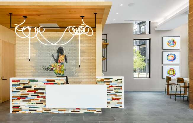 a reception area with a white reception desk and a mosaic wall