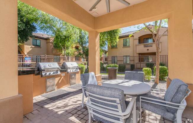 A patio with a table and chairs is surrounded by a wall.