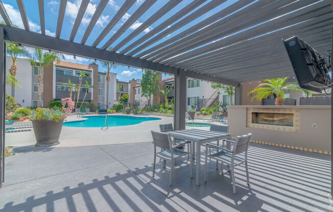a patio with a table and chairs next to a pool at City View Apartments at Warner Center, California