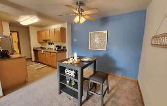 A kitchen with a dining table and chairs in the middle of the room.