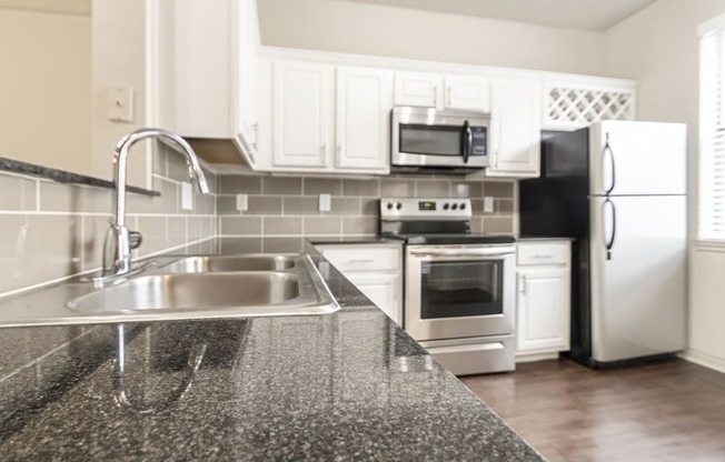 This is a picture of the kitchen of the 1320 square foot 2 bedroom, 2 and 1/2 bath floor plan at The Brownstones Townhome Apartments in Dallas, TX..