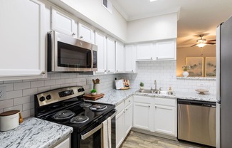 a kitchen with stainless steel appliances and marble counter tops