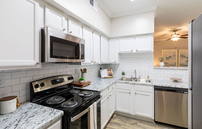 a kitchen with stainless steel appliances and marble counter tops
