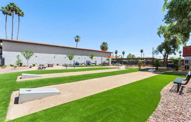 A park with a playground and a green lawn.