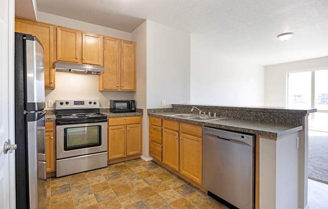 A kitchen with wooden cabinets and granite countertops.