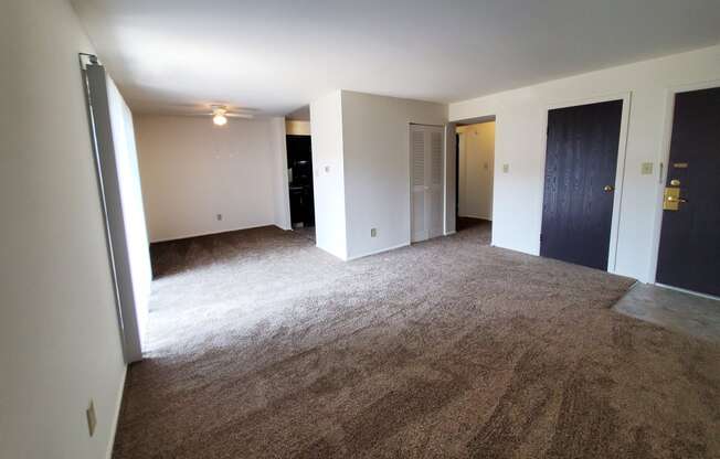 Living room with carpet and a door to a closet in a 1 bedroom apartment at Carriage House West.