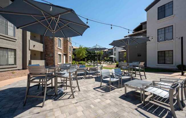 patio with tables and chairs and umbrellas at the residences at silver hill in suitland