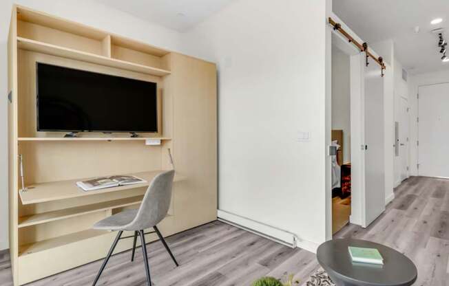 a bedroom with a medium sized bed and a chair in front of a tv