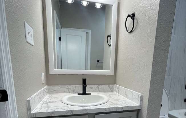 A bathroom with a mirror and a cabinet.