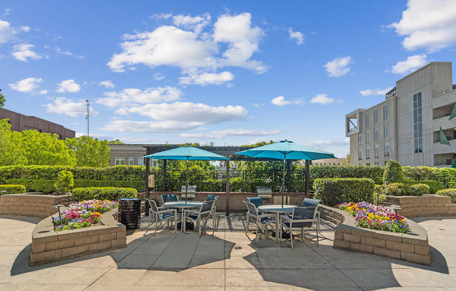 A patio with tables and chairs under umbrellas.