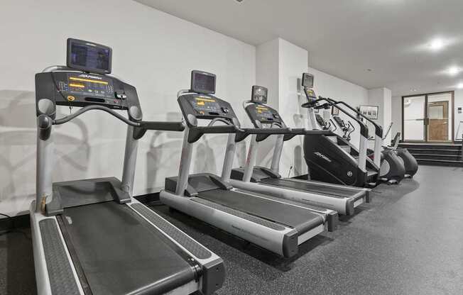 A row of treadmills in a gym.
