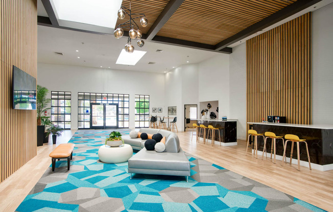 the clubhouse of an apartment building with a blue rug and furniture at Presidio Palms Apartments, Arizona, 85701