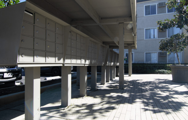 A row of mailboxes are lined up on a sidewalk.