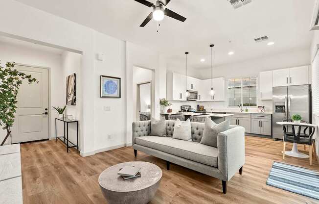 A modern living room with a grey couch and a round coffee table.