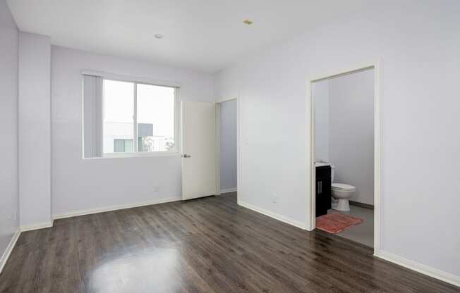 a living room with white walls and a door to a bathroom