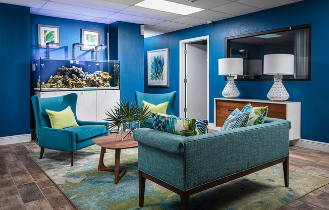 a living room with blue chairs and a fish tank at Fairways of Inverrary, Lauderhill, 33319