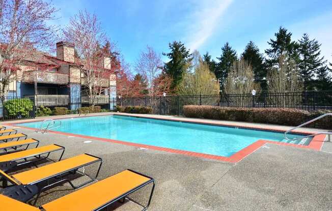 A pool surrounded by trees and a building.