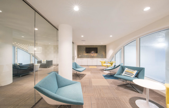 Small lounge area with blue seating inside SOMA at Brickell apartments.