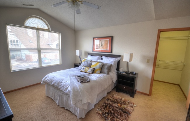 a bedroom with a bed and a ceiling fan