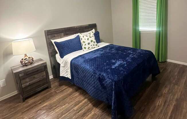 A bedroom with a bed, nightstand, and a ceiling fan.