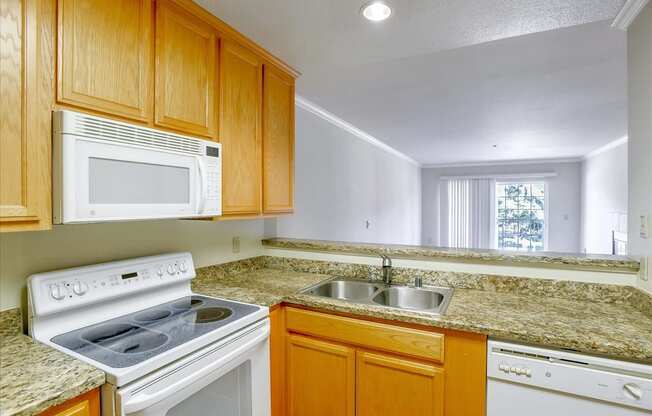 A kitchen with wooden cabinets and granite countertops.