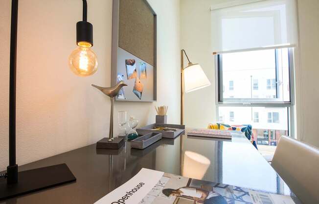 A modern desk with a lamp, a light bulb, and a few other items on it.