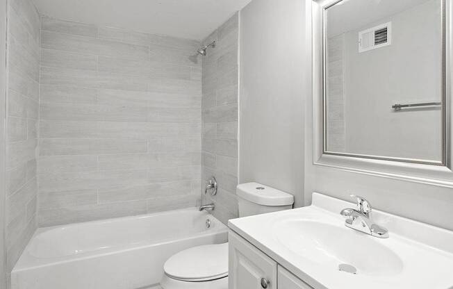 A white bathroom with a toilet, sink, and tub.