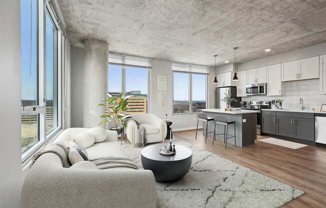 A modern living room with a grey couch and a round table.