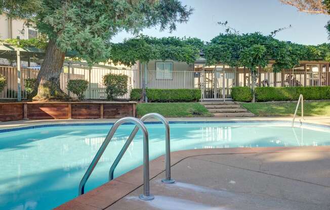 a swimming pool in front of a house with a pool